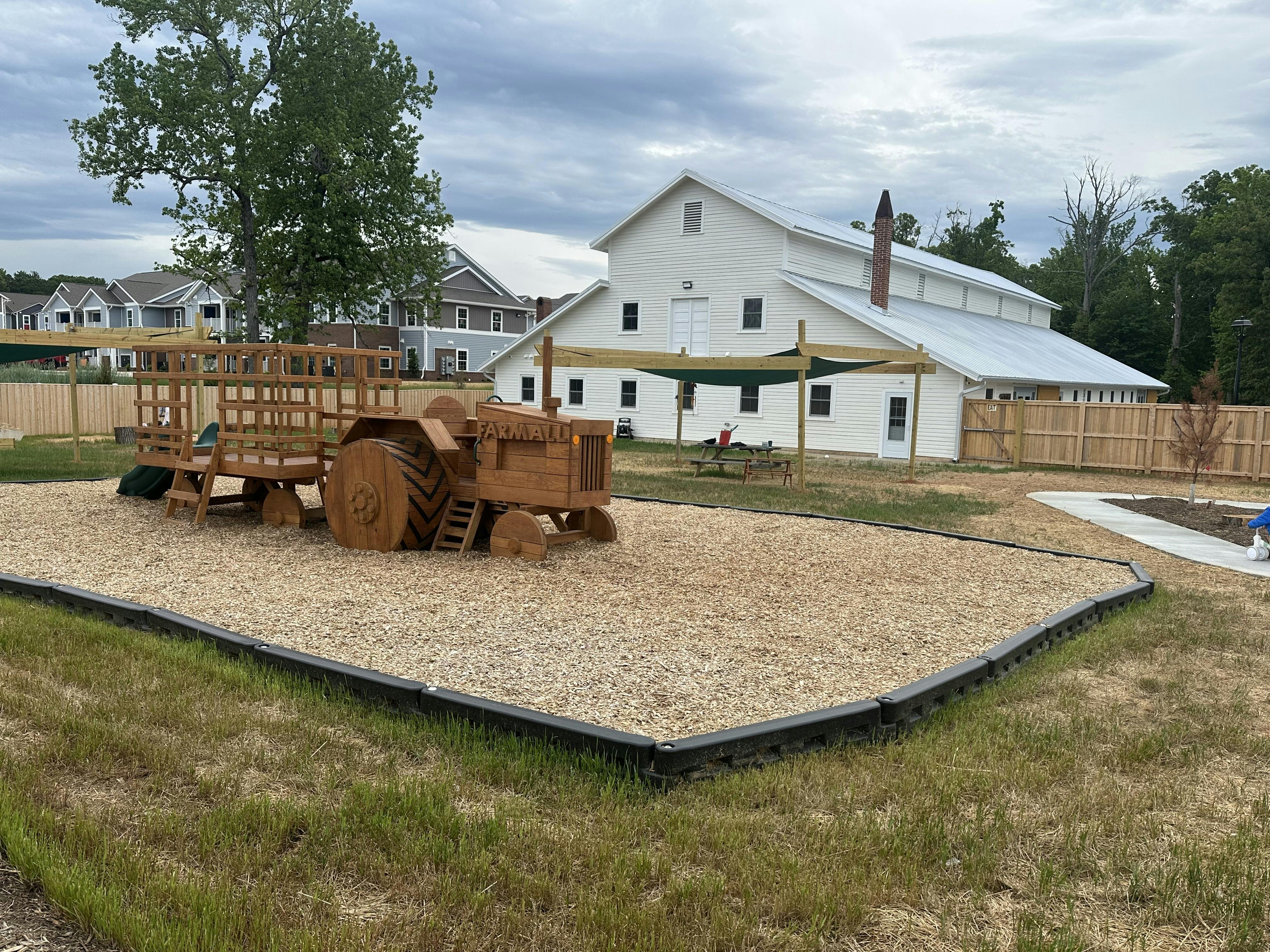 Wooden tractor and wagon on a playground with wood chips
