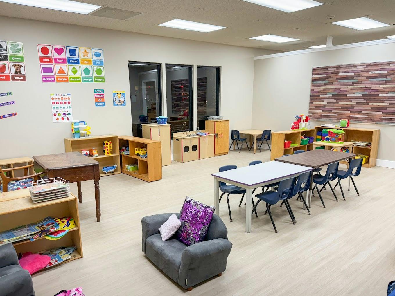 Empty preschool classroom with small tables and chairs