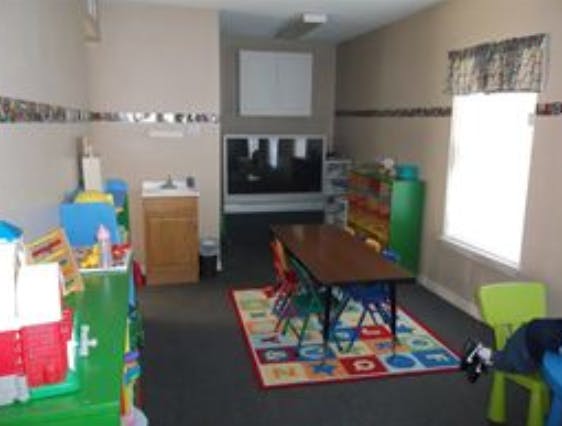 Empty classroom with small table and chairs on a colorful rug