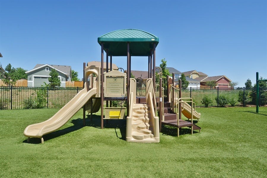 Playground structure with slides and stairs on green grass