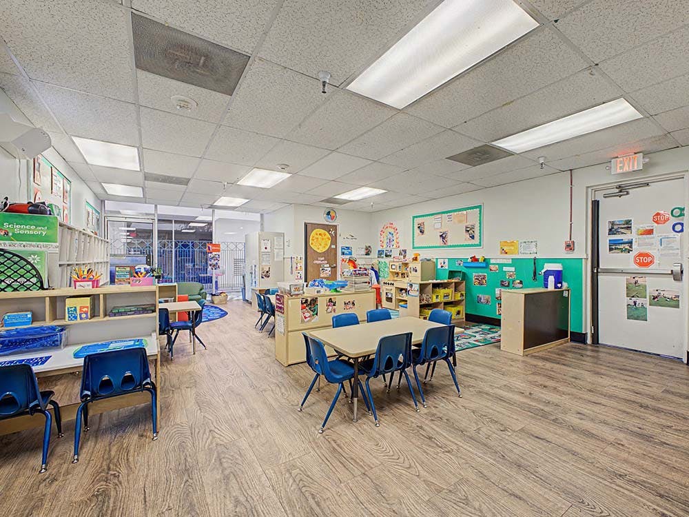 Classroom with small tables and chairs, shelves, and decorations