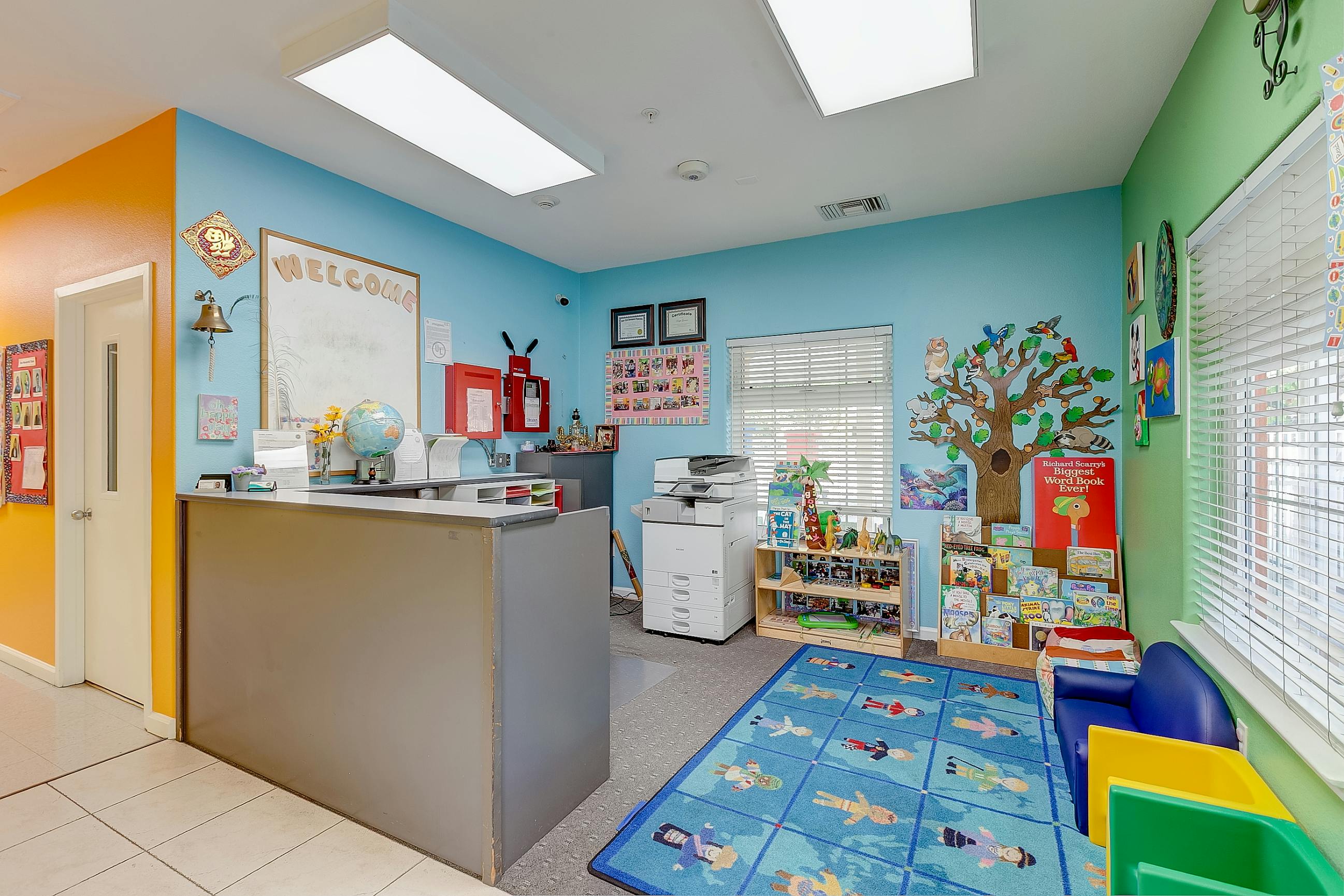 Reception area of a children's daycare center with a desk and reading corner