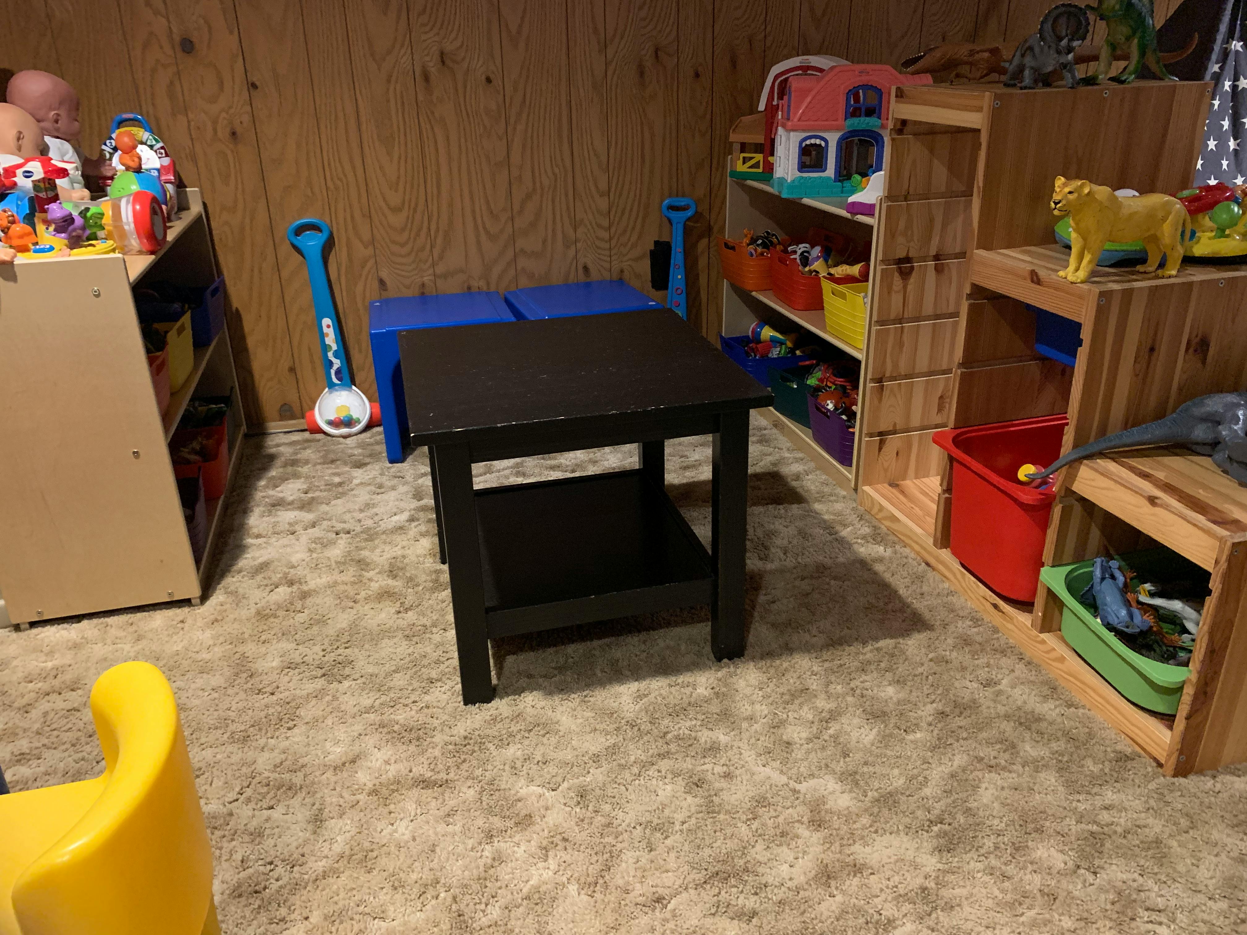 Playroom with toy shelves, bins, and a small table