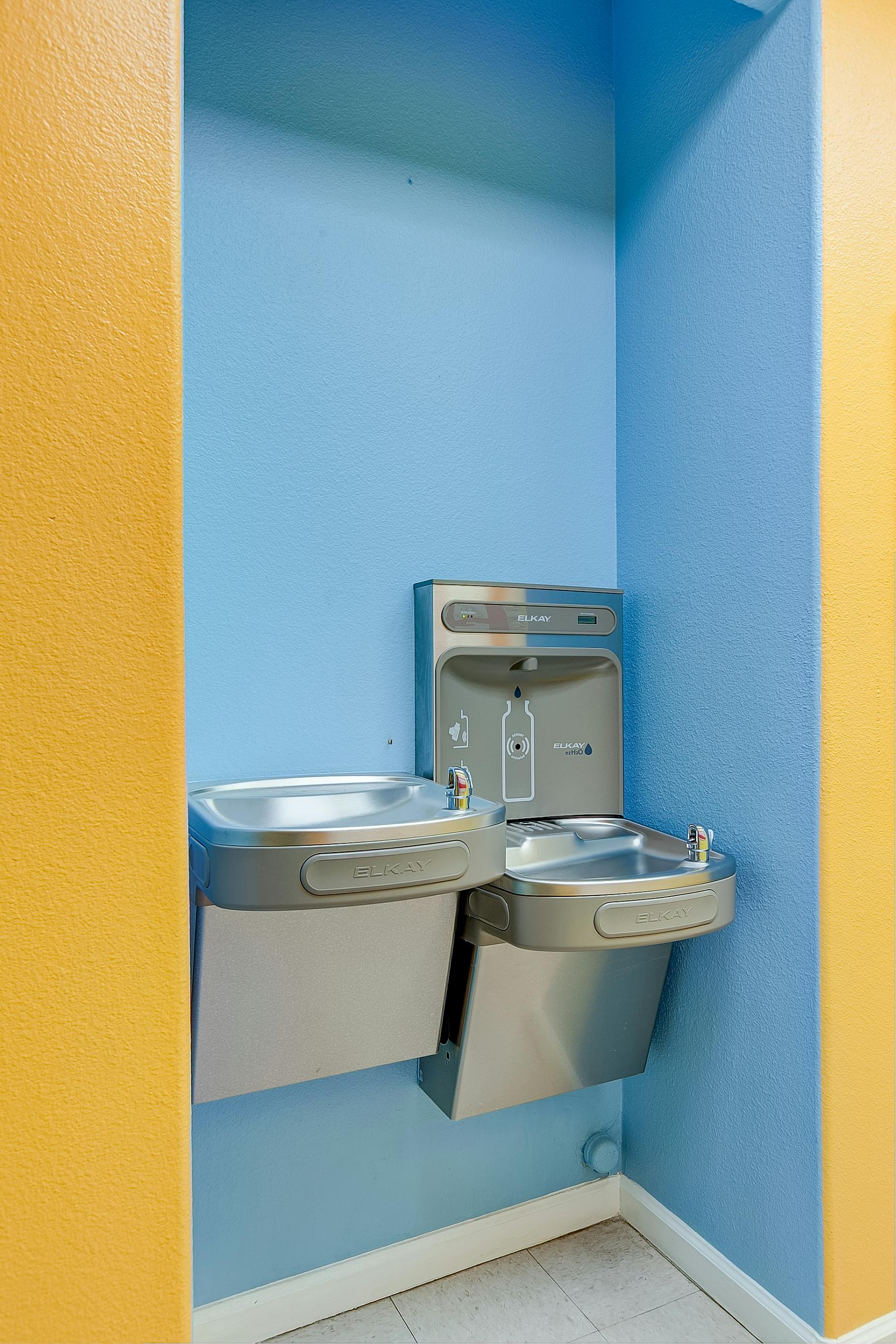 Elkay water fountain and bottle filling station mounted on a blue wall