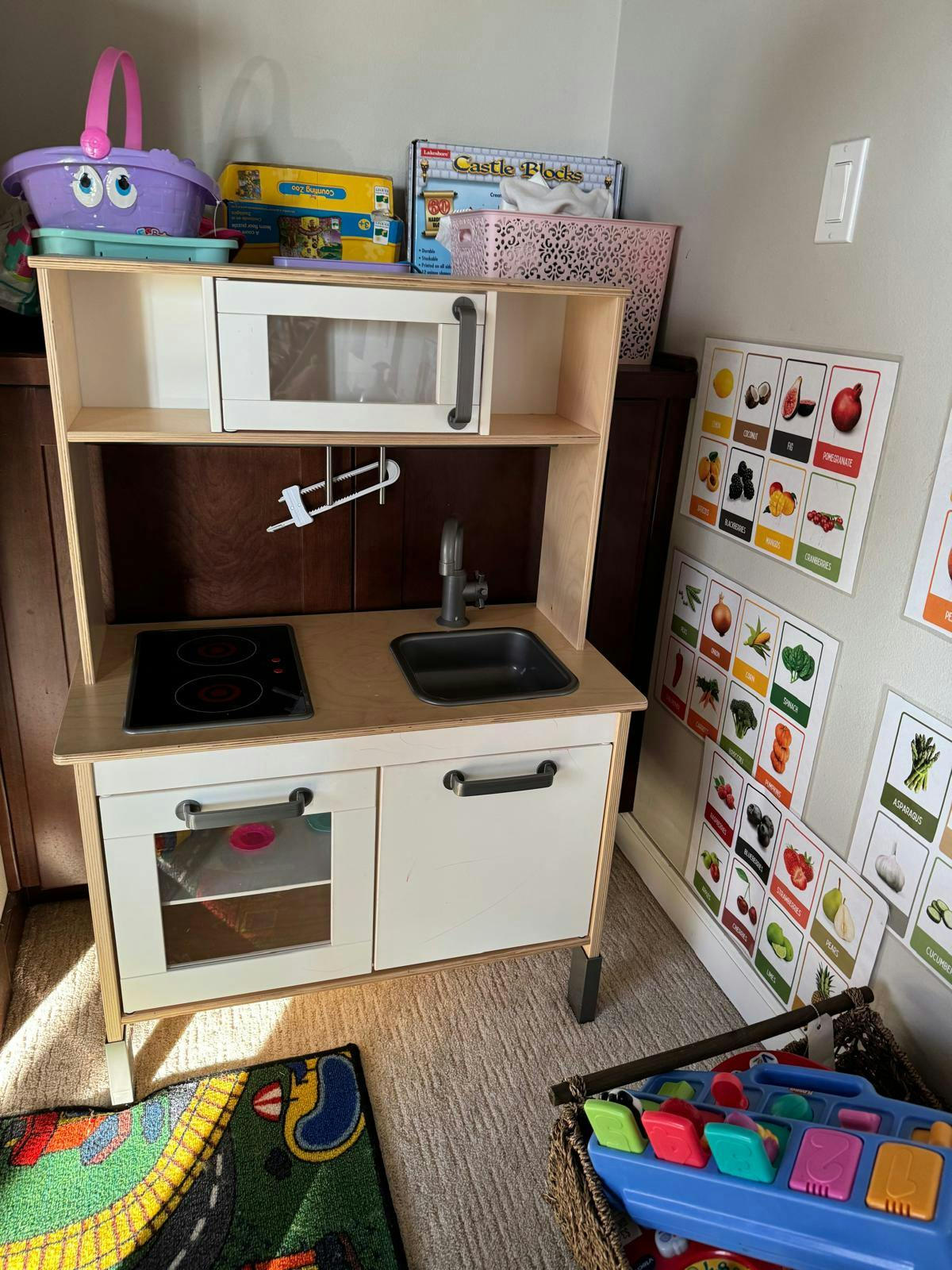 Child's play kitchen with a sink, stovetop, and oven