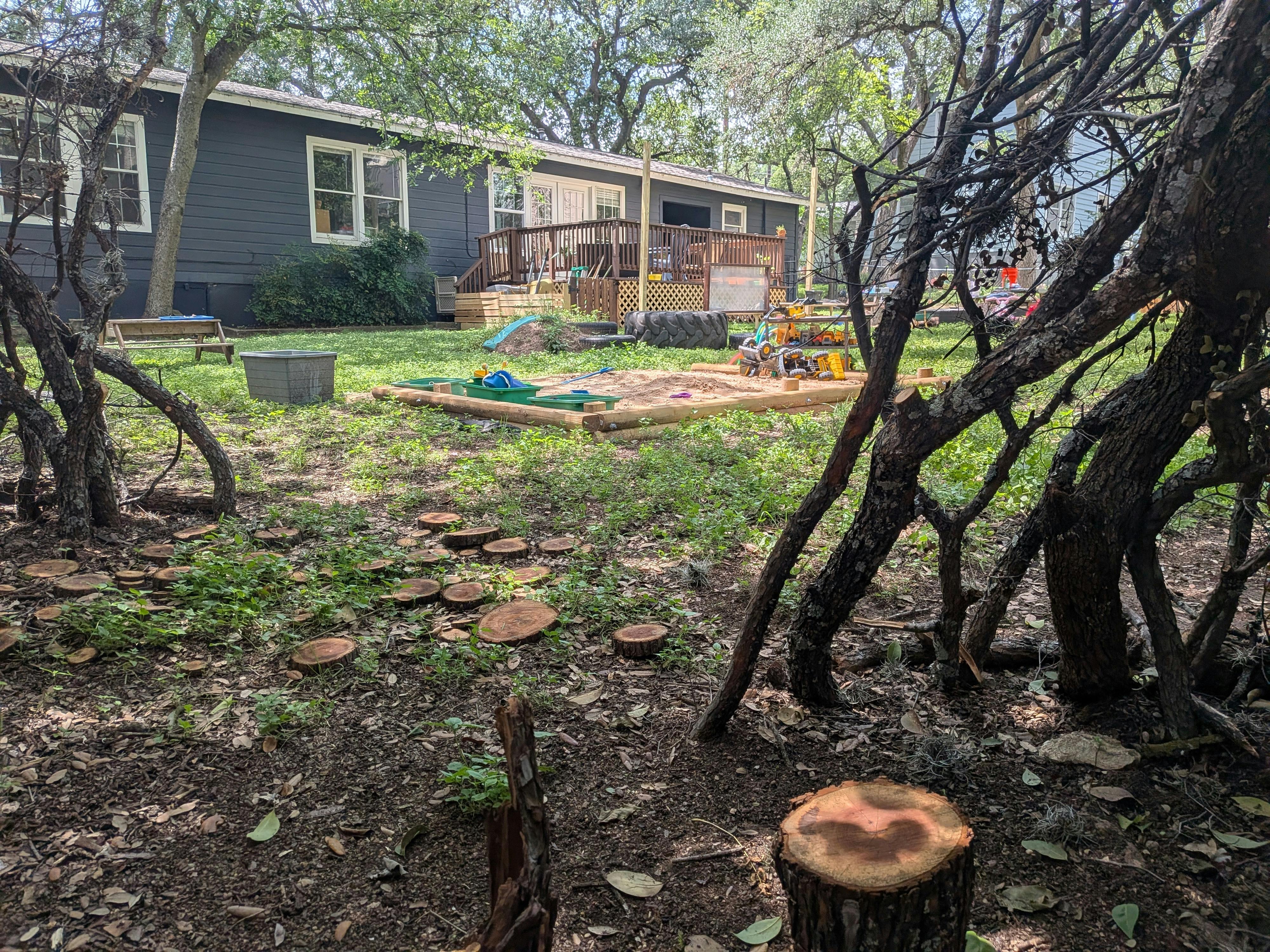Children's playground with a sandbox and toys in front of a house