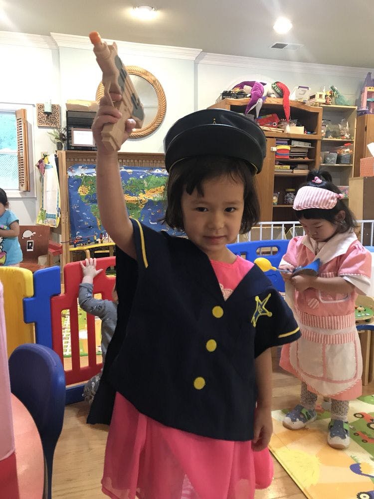 Child in costume holding up a toy gun