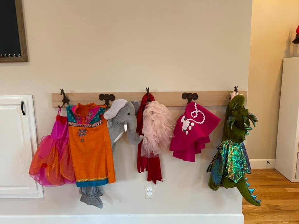 Children's dress-up clothes hanging on hooks