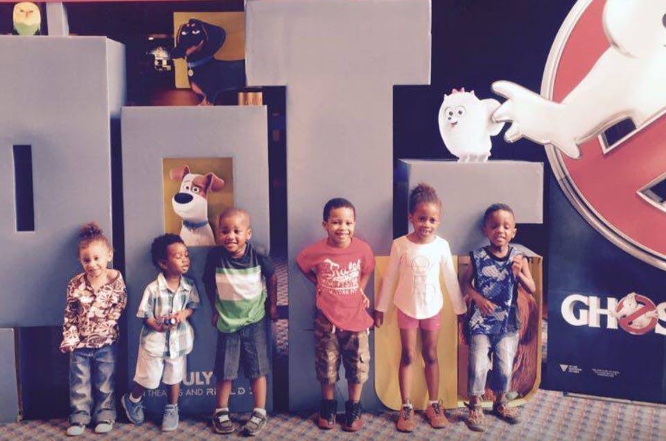 Five children standing in front of movie posters