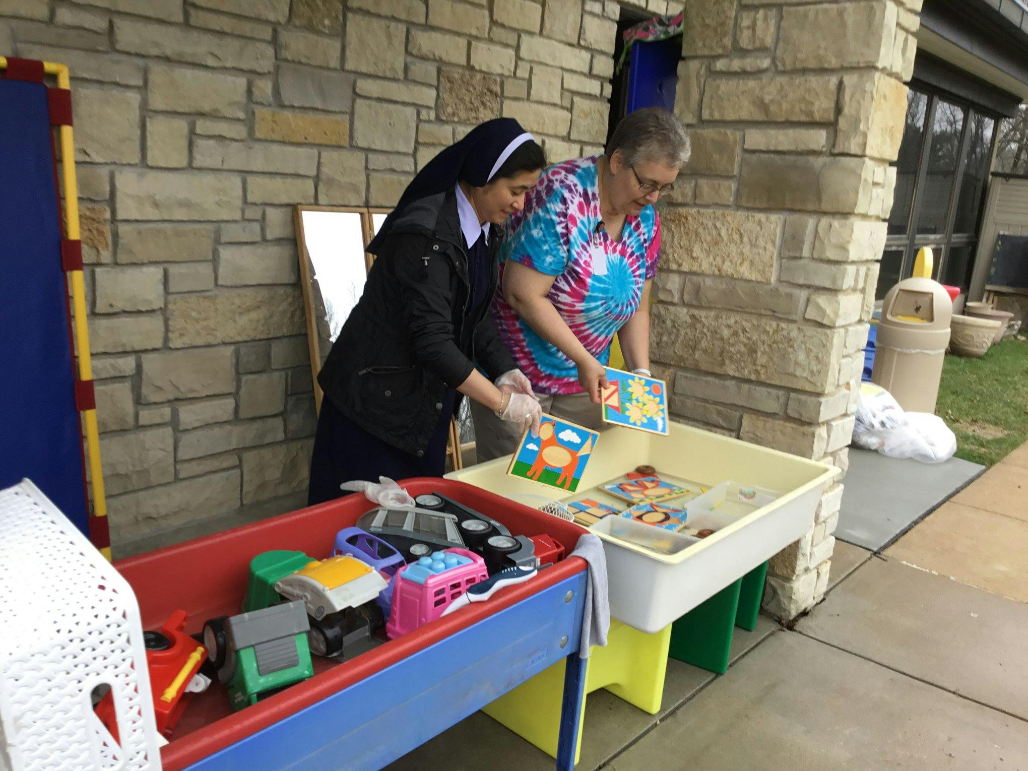 Two people sorting items into bins