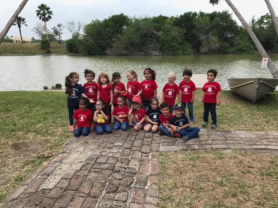 Group of children posing by a body of water