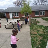 Children on a patio with a building in the background