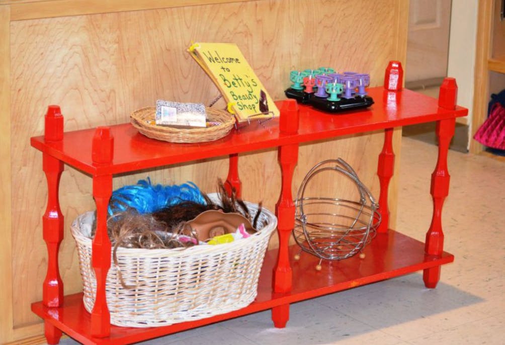 Red two-tier shelf with a basket of items and a wire basket