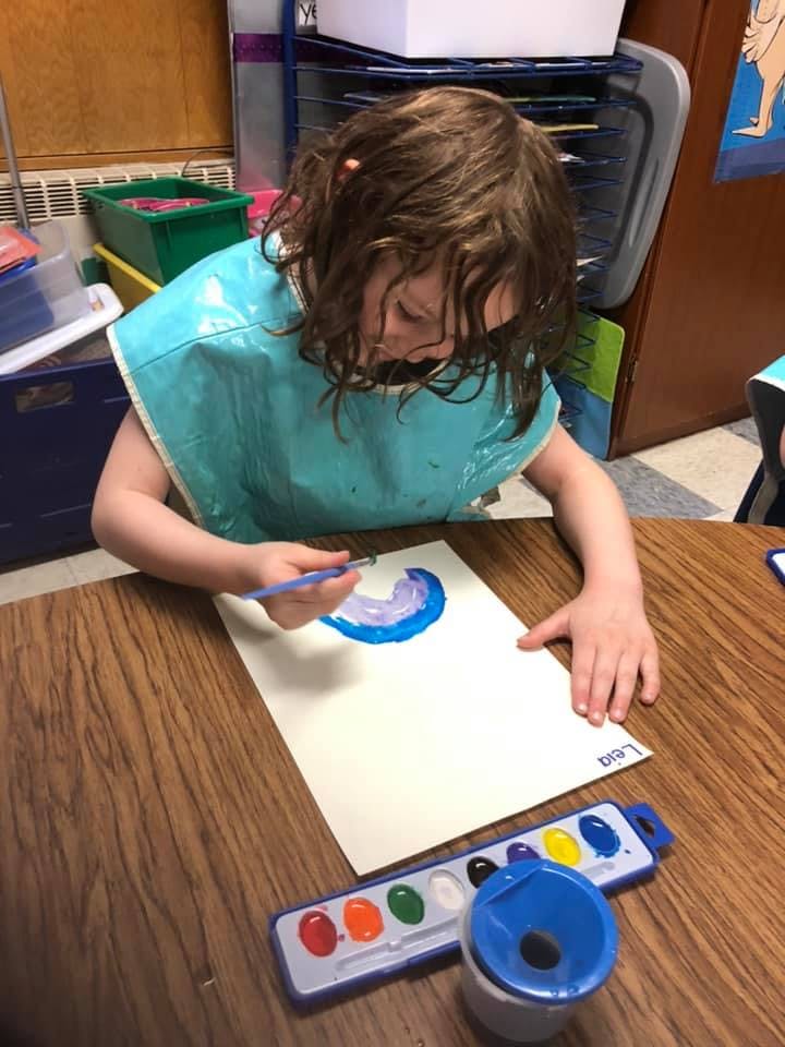Child painting on paper with watercolors
