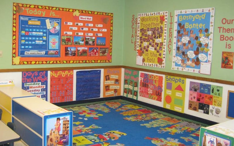 Classroom with learning posters on the walls and a colorful rug on the floor