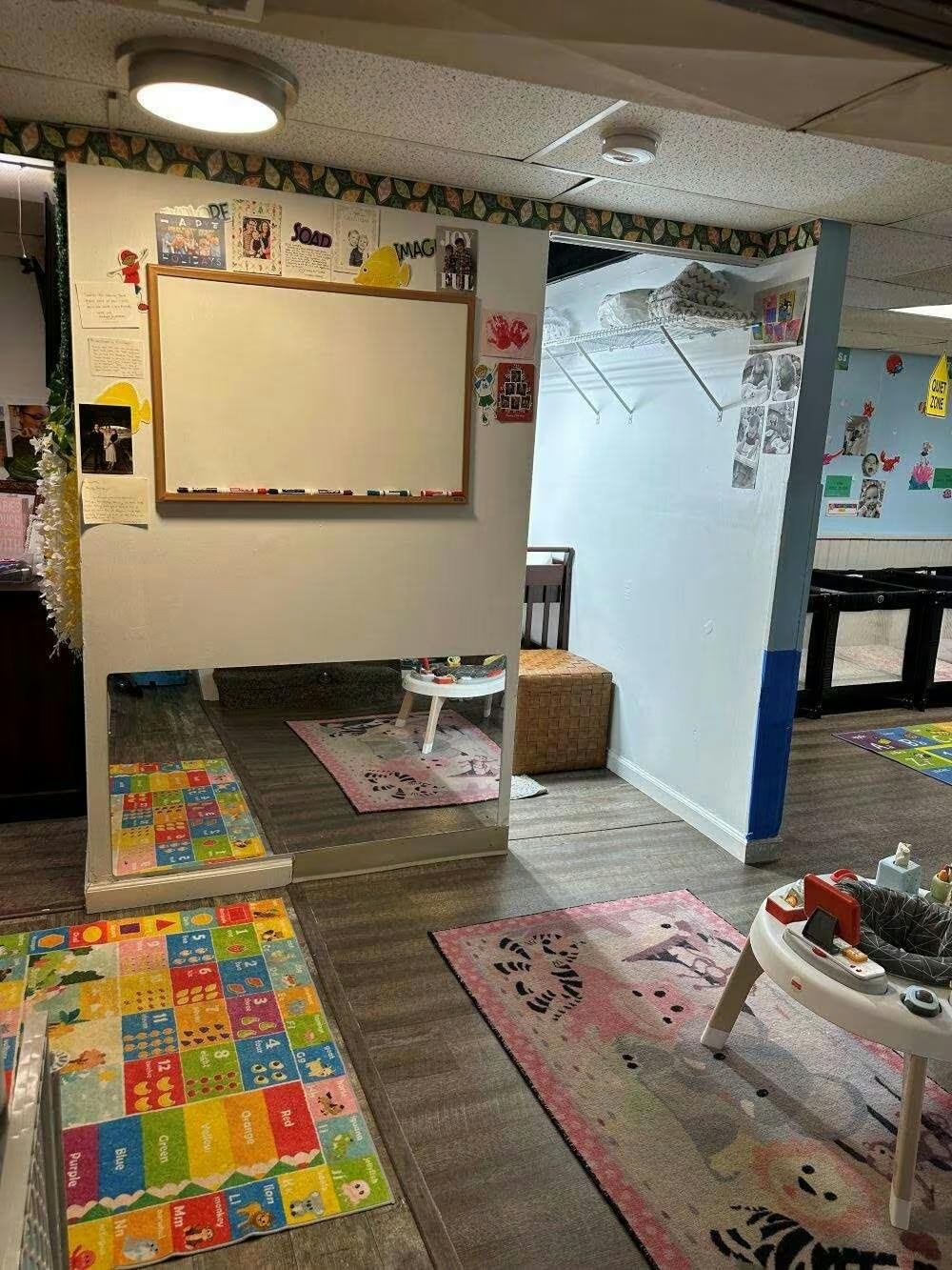 Childcare room with play mats and a whiteboard on the wall