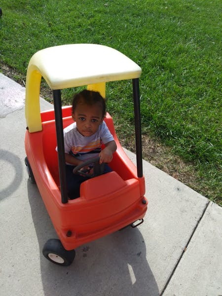 Child sitting in a toy car