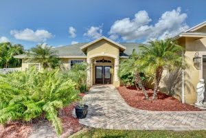 Front exterior of a house with a paved walkway and landscaping