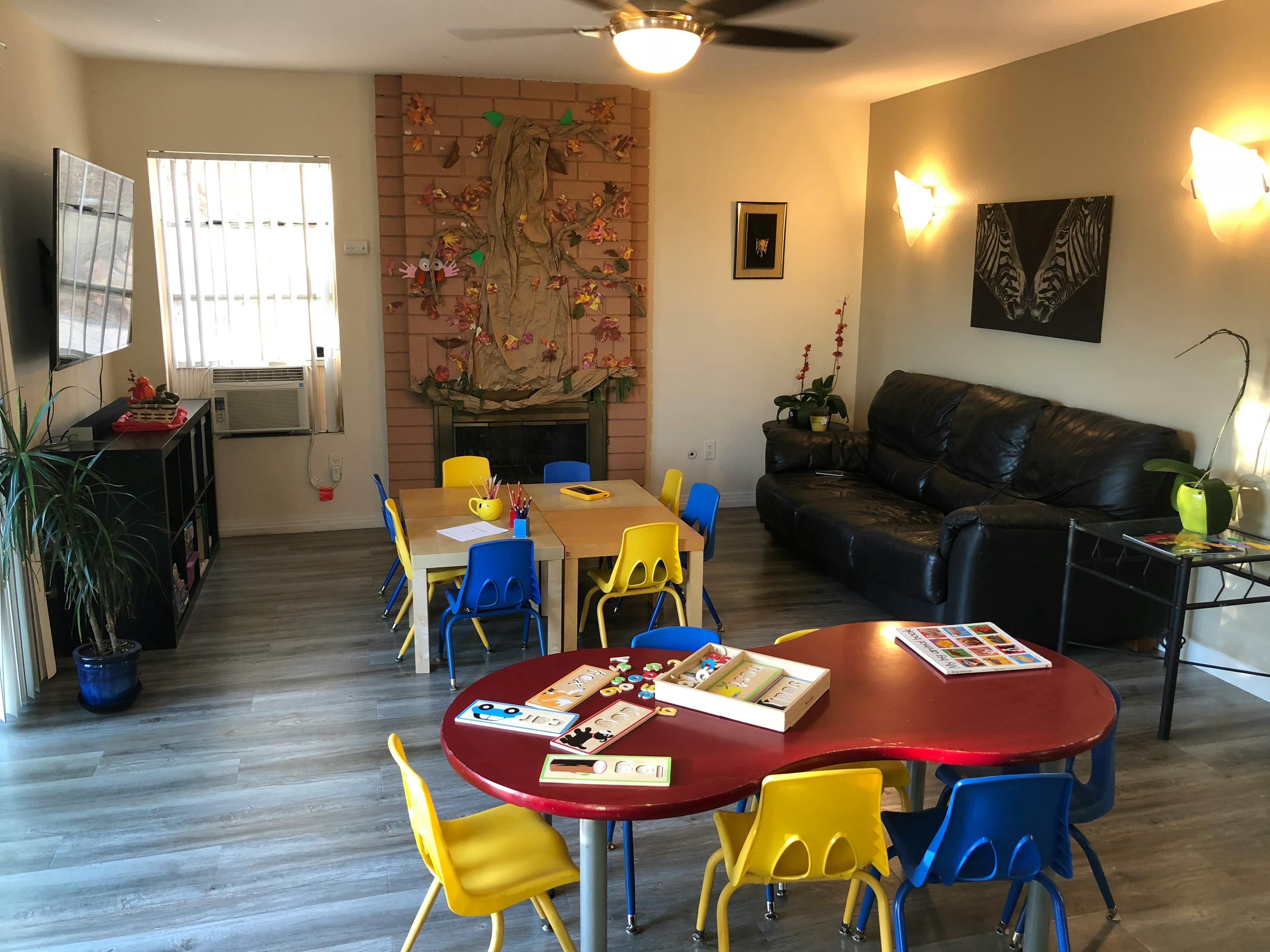 Living room with children's tables and chairs, and a black sofa