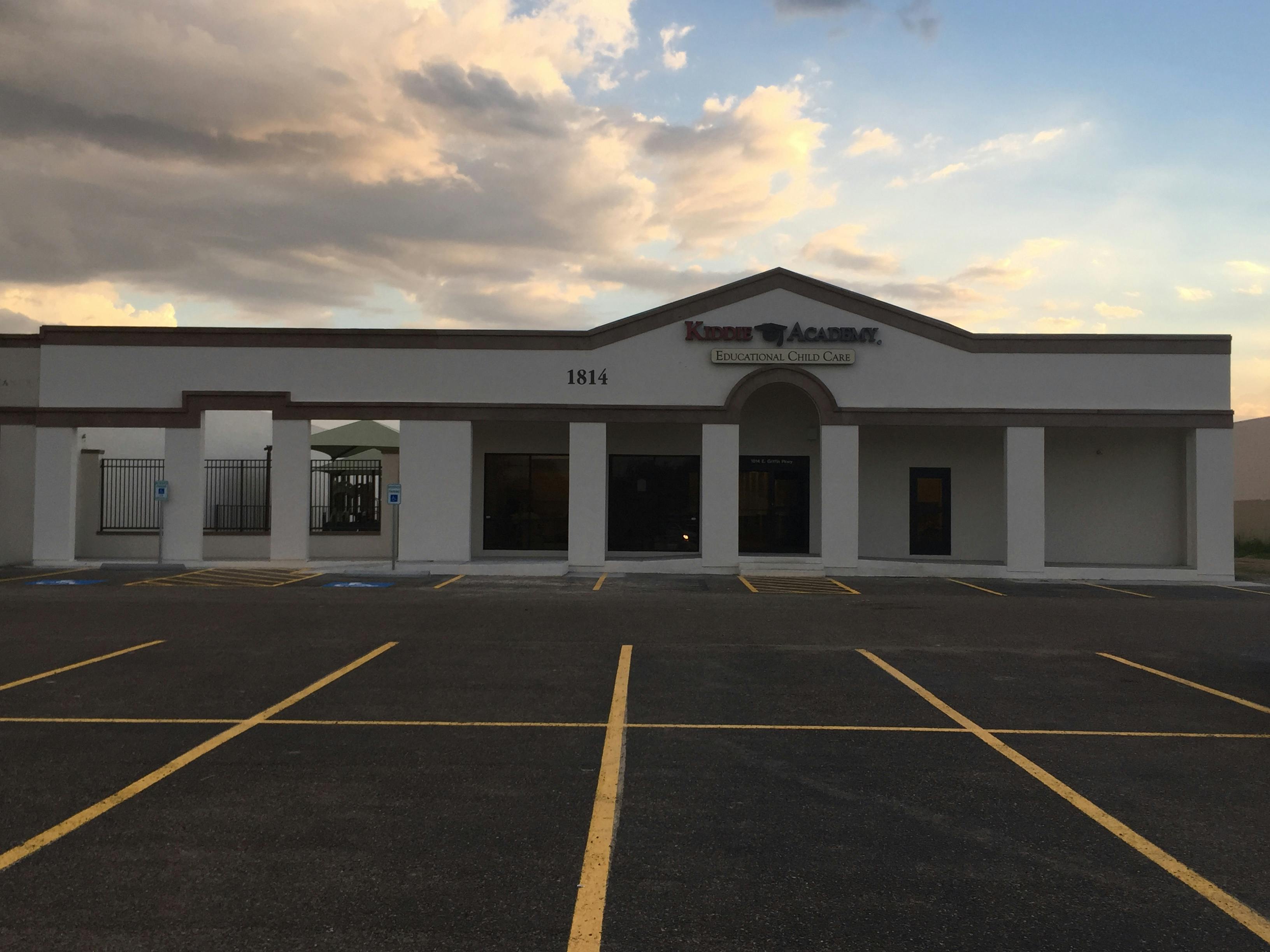 Building with columns and a parking lot in front