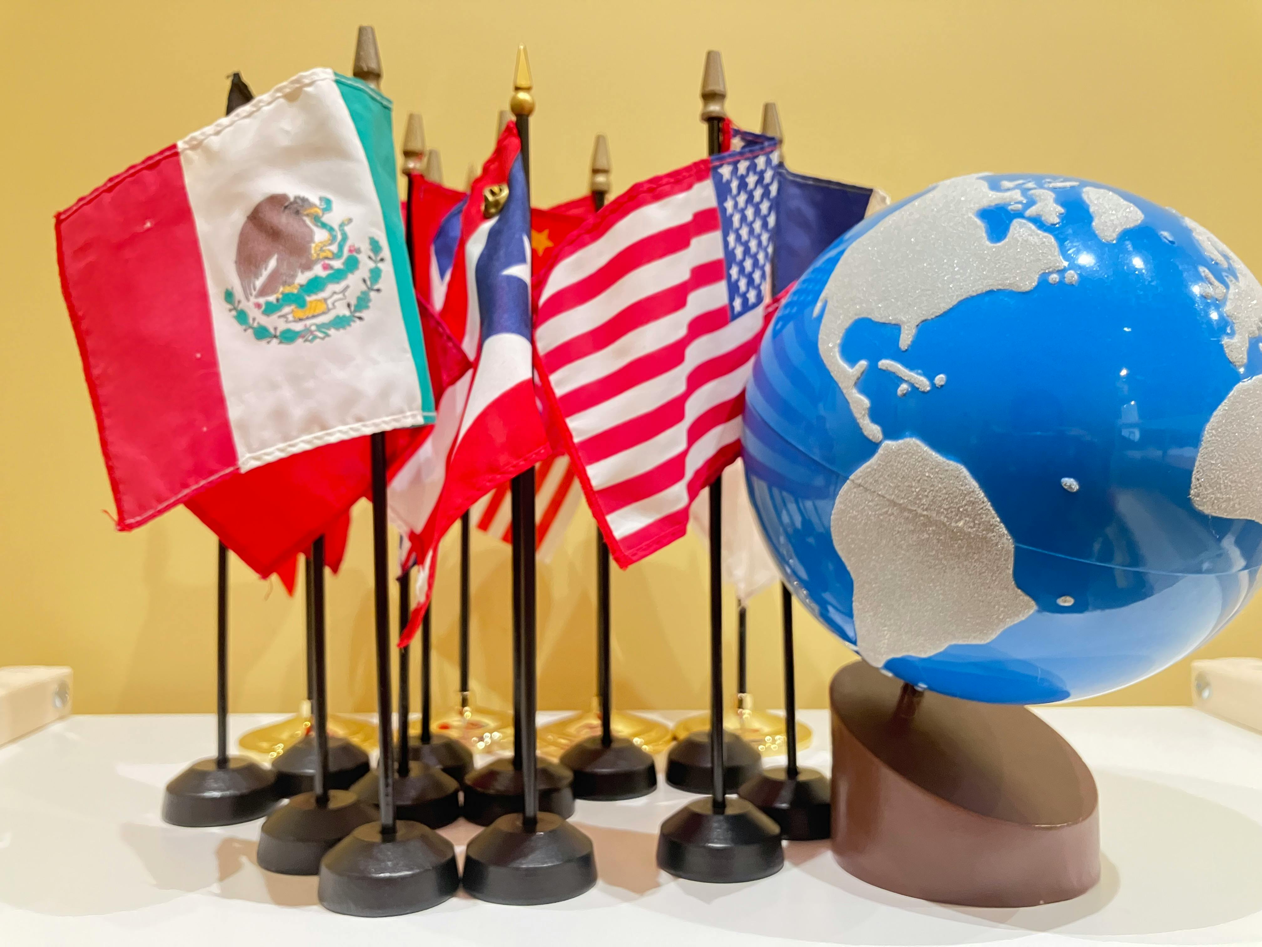 Tabletop globe next to a row of small flags