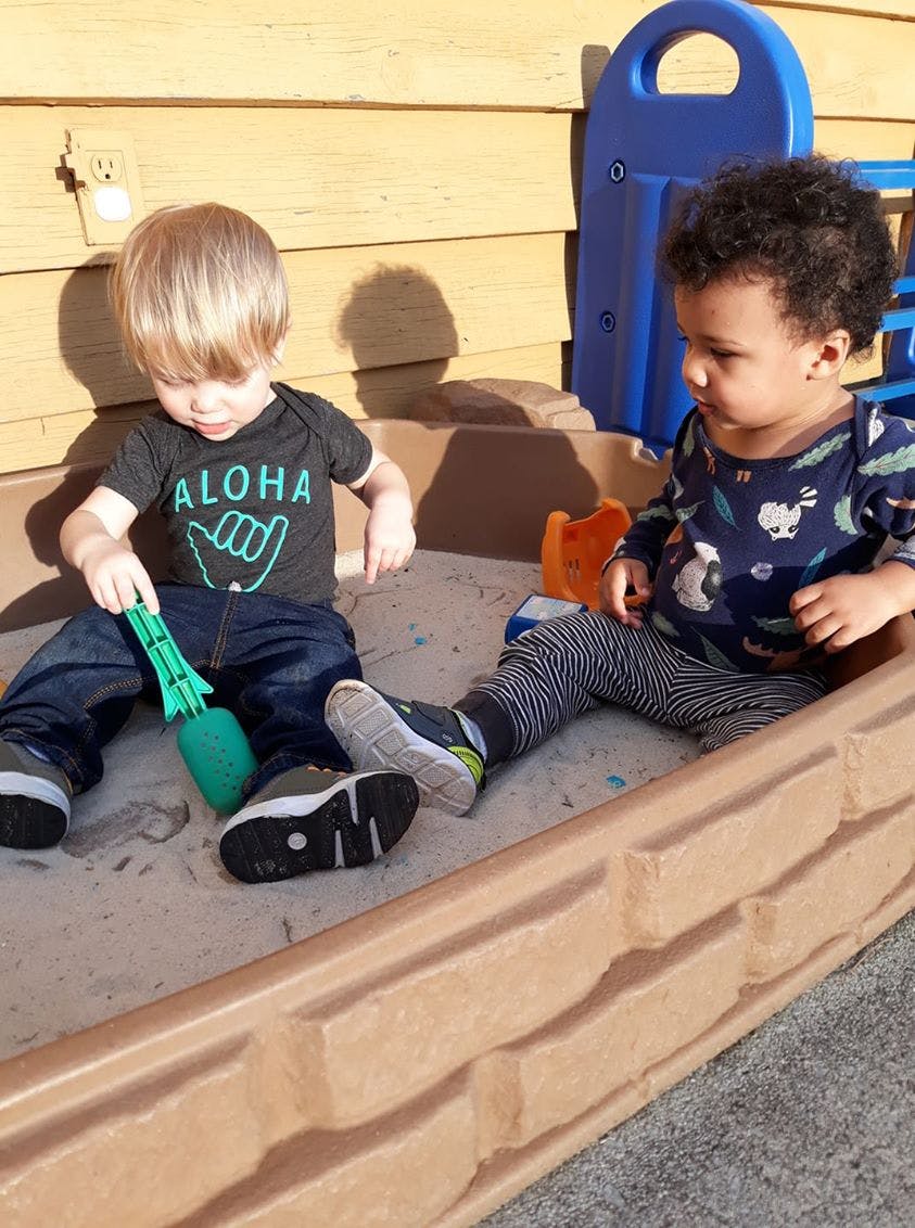 Two children playing in a sandbox