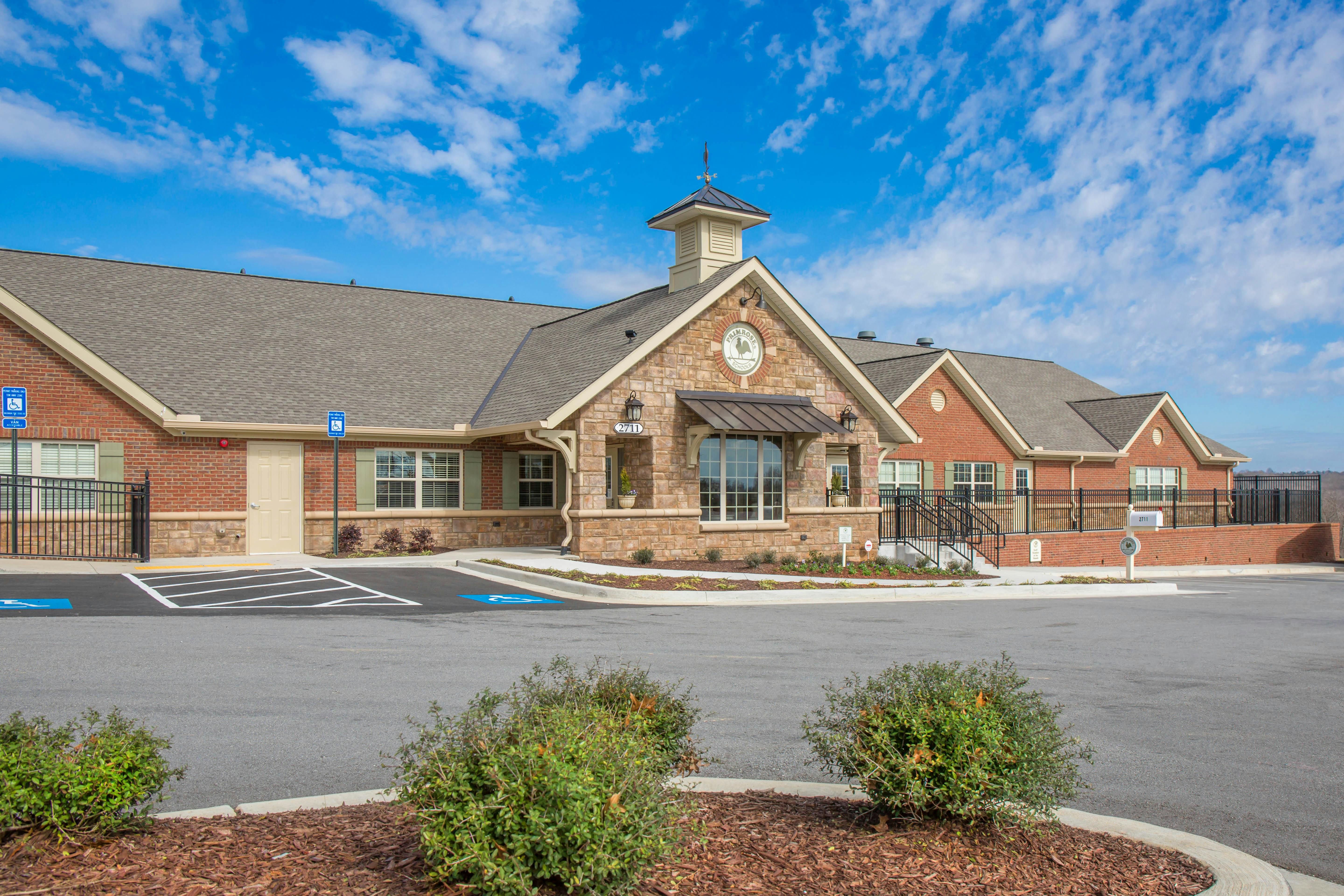Building exterior with brick and stone, Primrose Schools sign, and parking lot