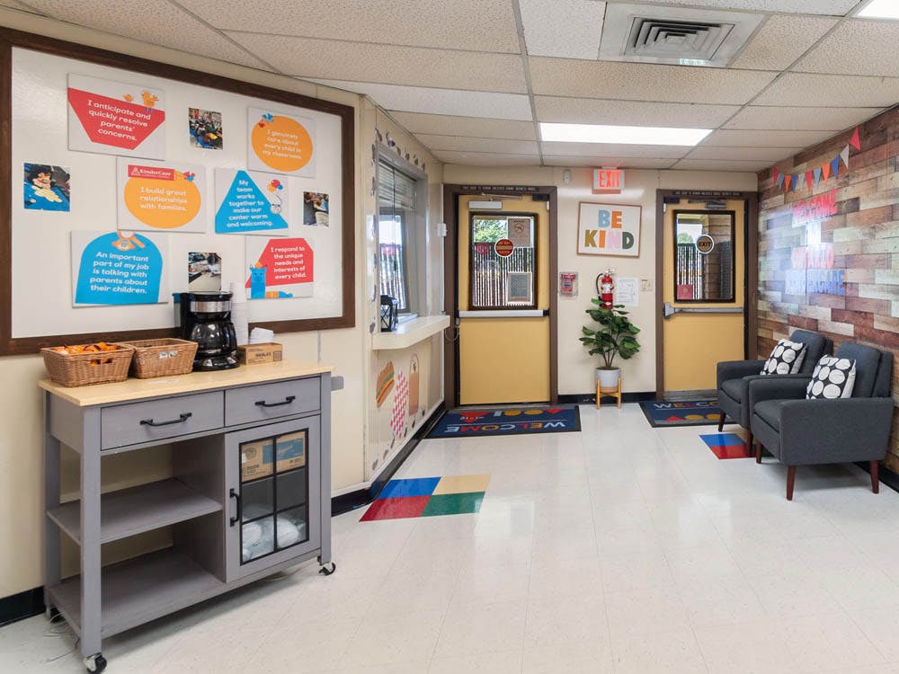Lobby area with a coffee station, seating, and "Be Kind" sign