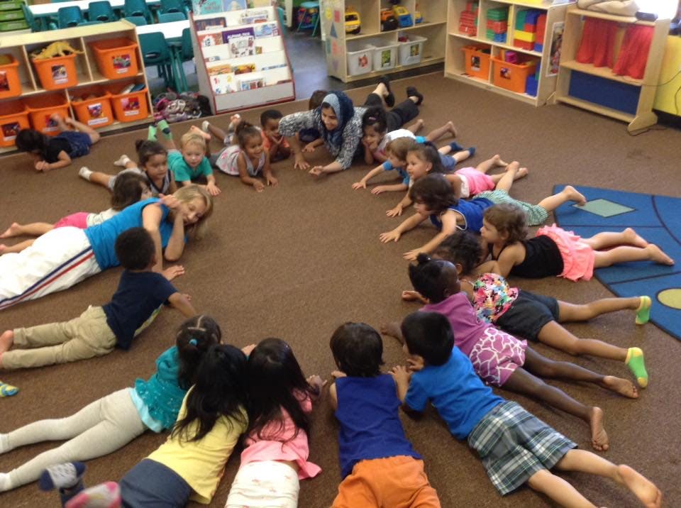 Adults and children lying on the floor in a circle