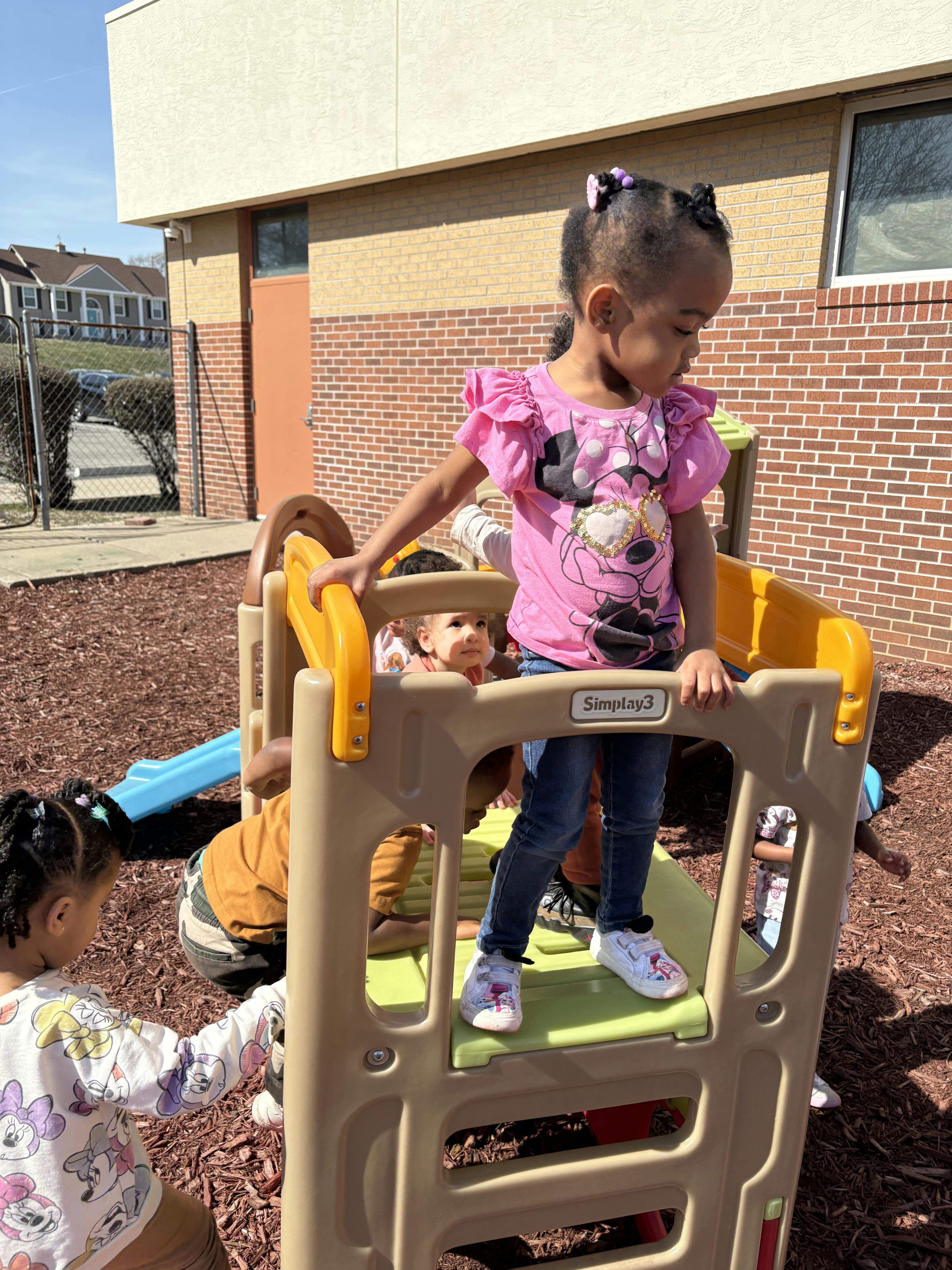 Child standing on a playground climber