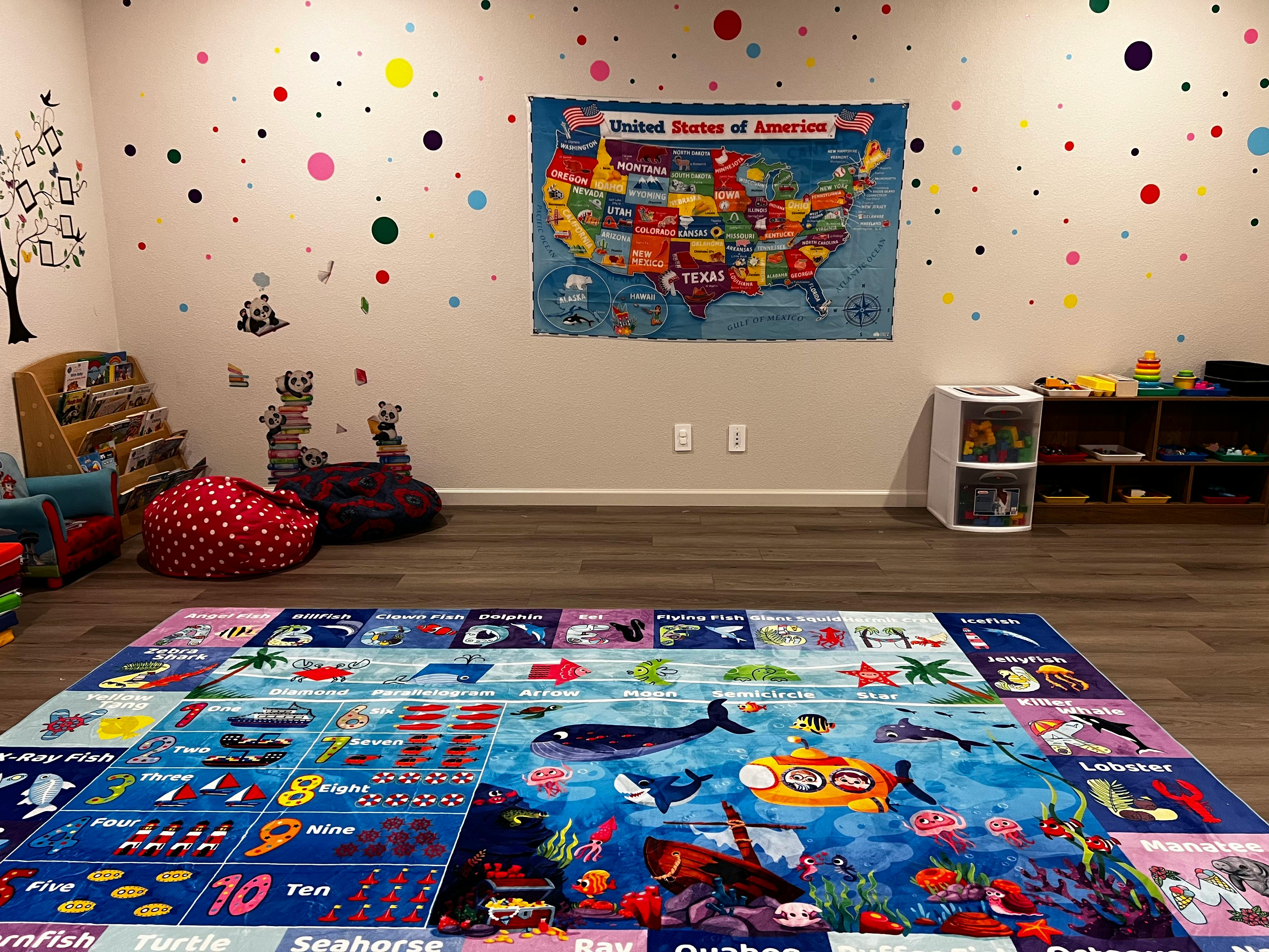 Playroom with a large colorful rug and a map of the United States on the wall