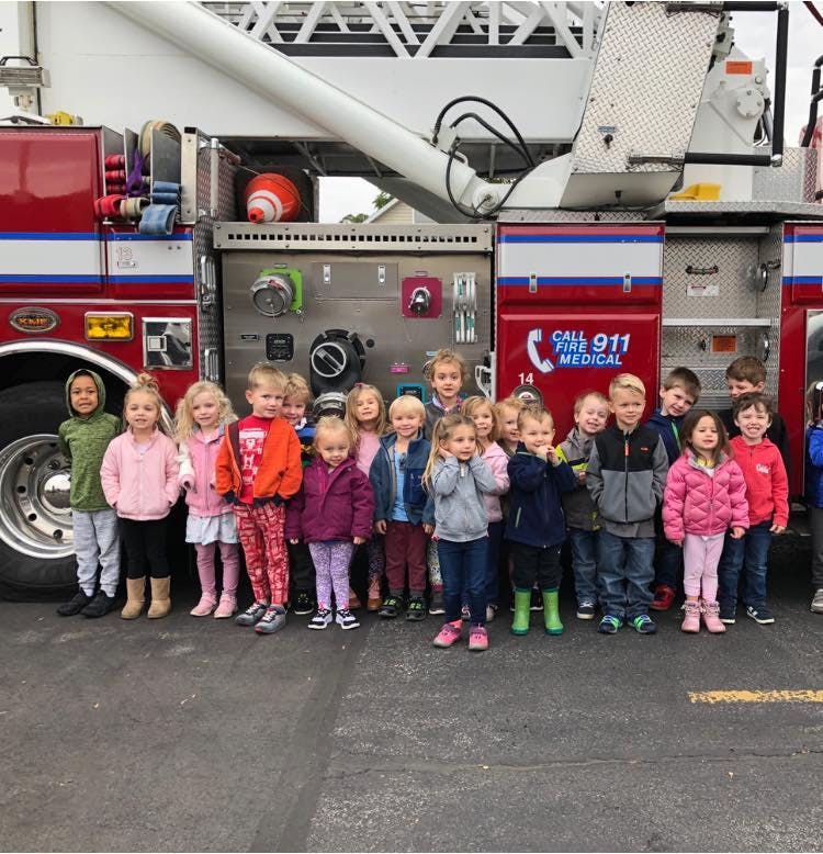 Group of children standing in front of a fire truck