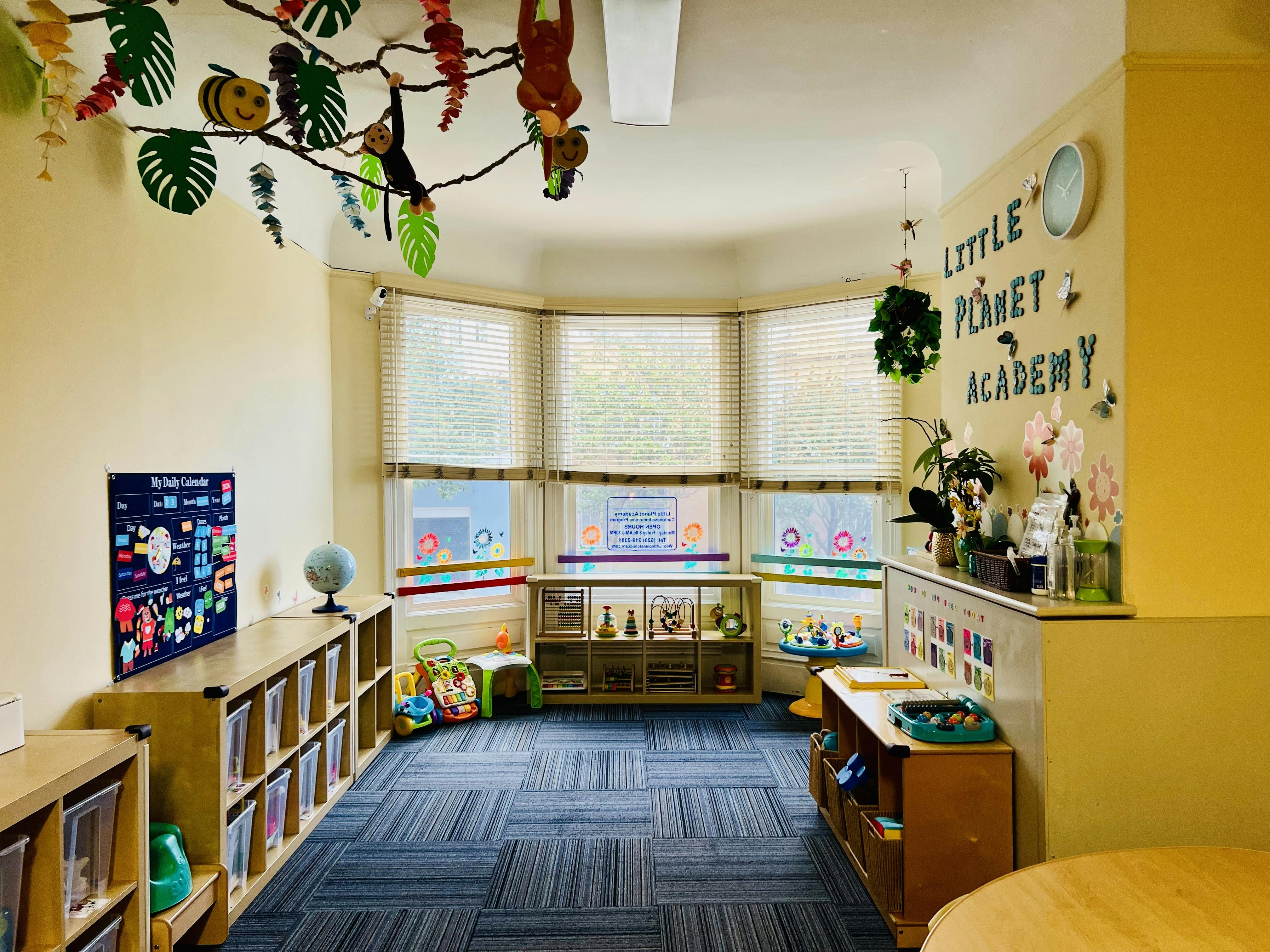 Classroom with bay windows, bookshelves, and hanging decorations