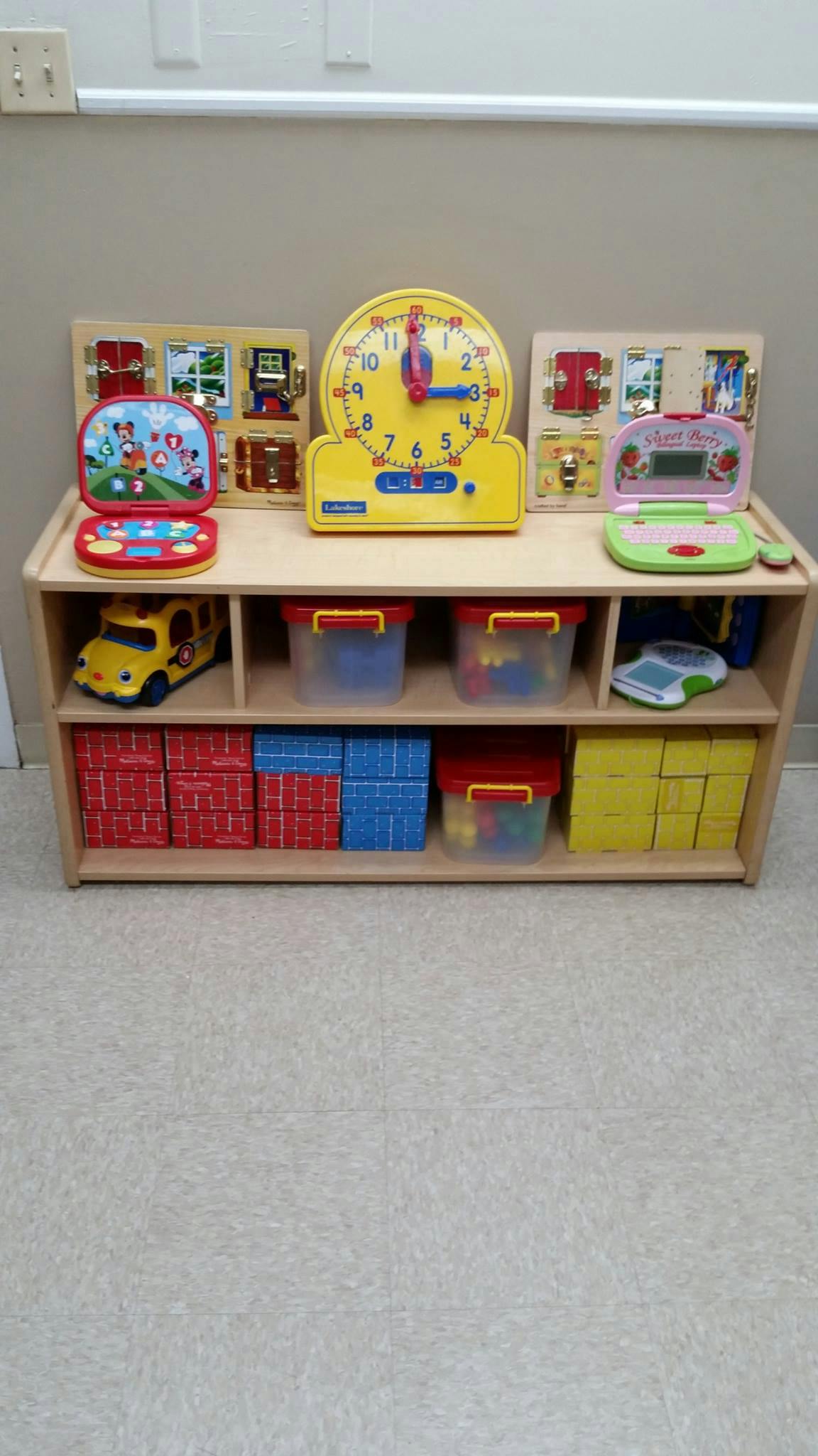 Wooden shelf with various children's toys and storage bins