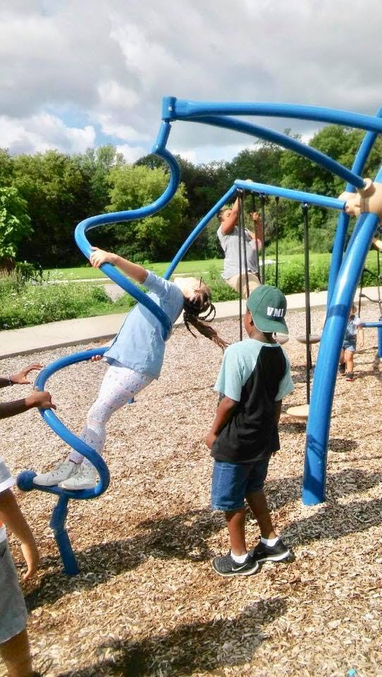 Child climbing on blue playground equipment