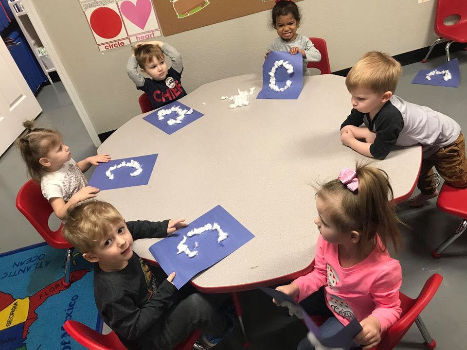 Children sitting around a table with craft projects