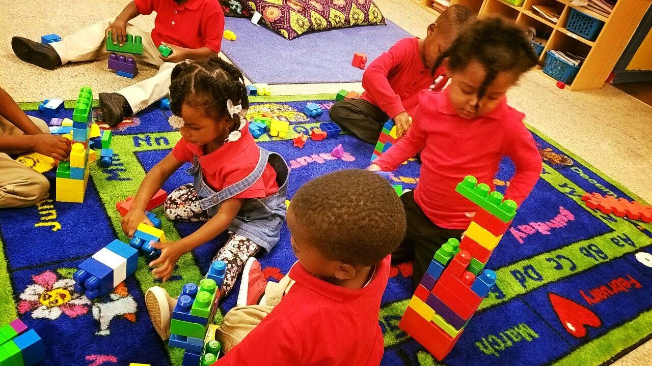 Children playing with colorful building blocks on a rug