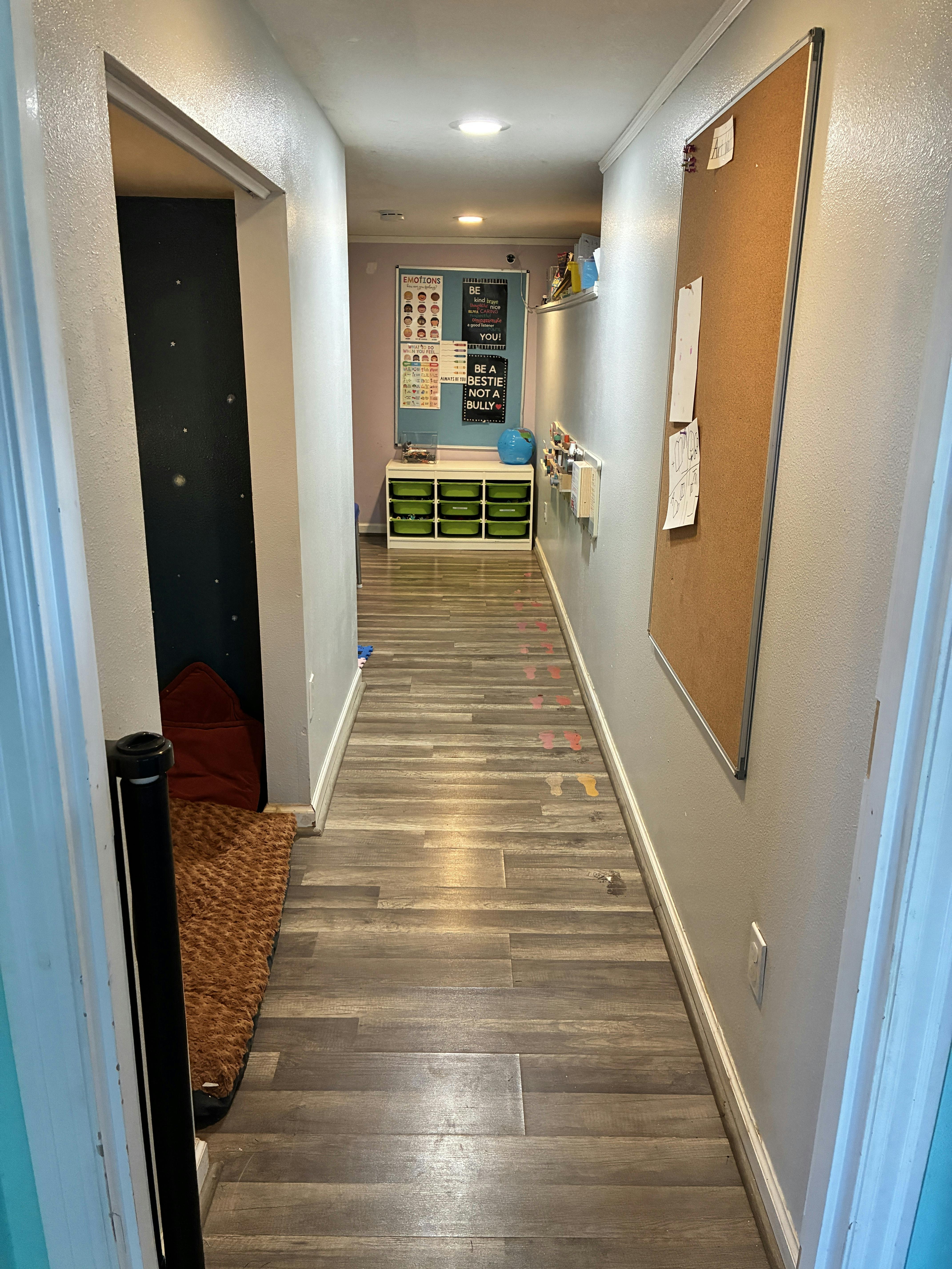 Hallway with posters about emotions and being kind, storage unit with green bins