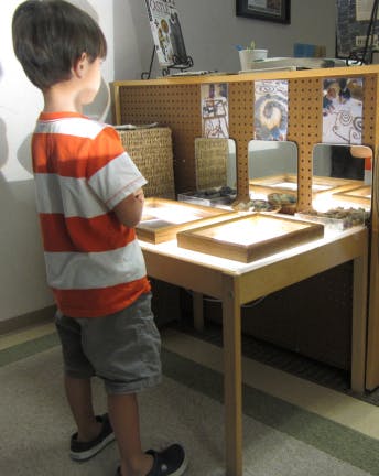 Child looking at items on a display table