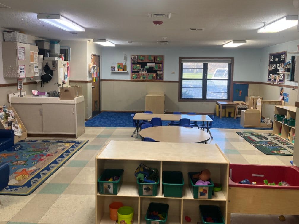 Classroom with tables and chairs, a sink, and storage cubbies