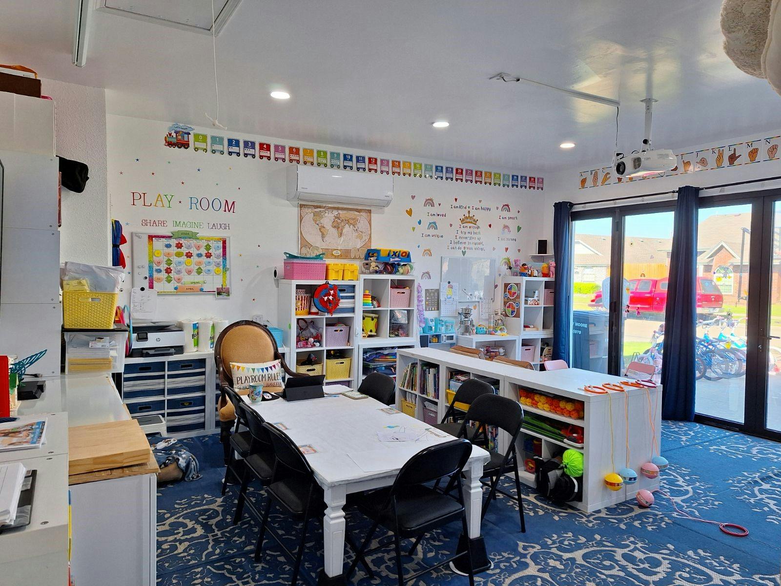 Playroom with tables, chairs, and shelves filled with items