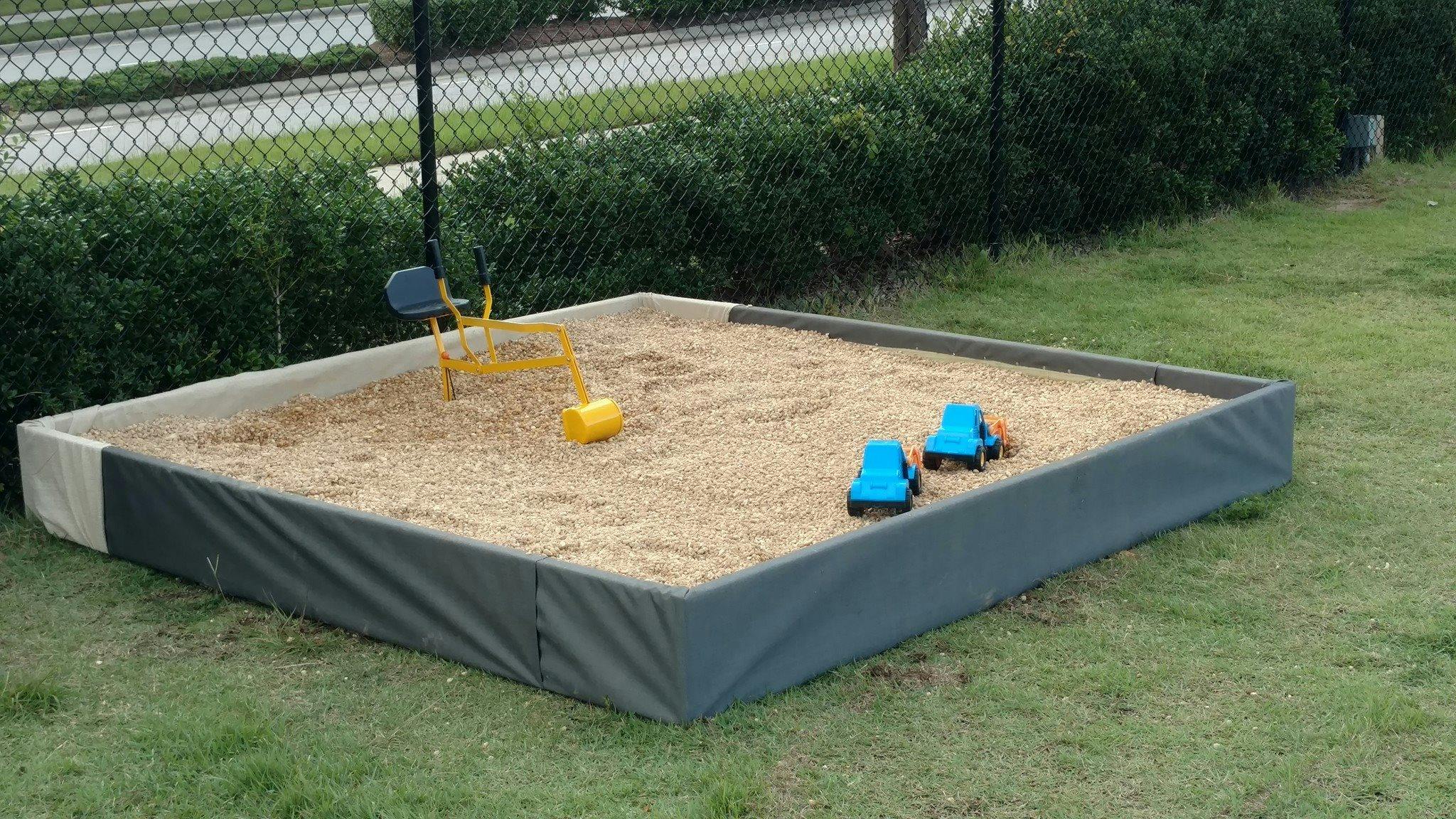 Sandbox with toy trucks and digger