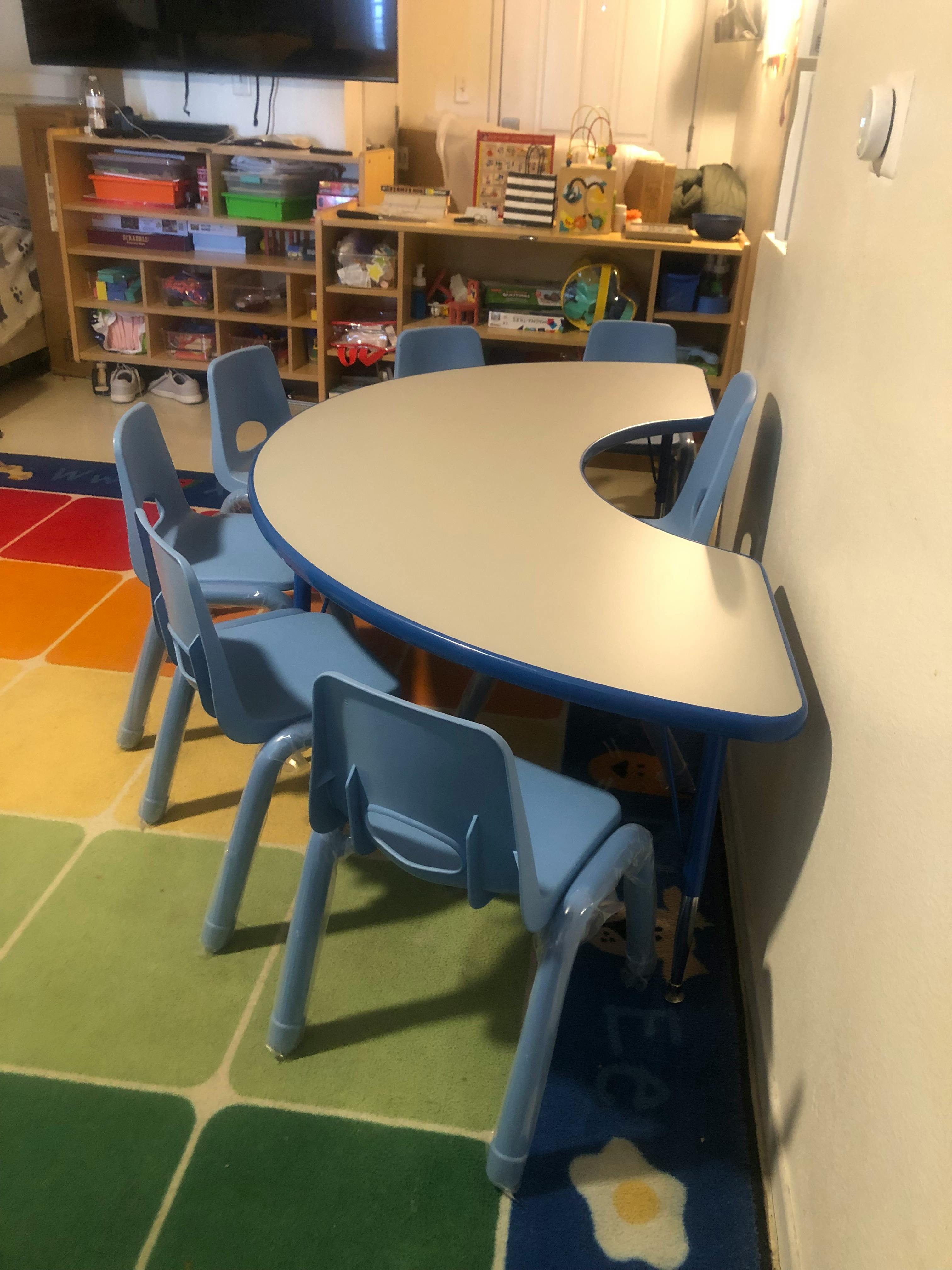 Classroom with a crescent-shaped table and blue chairs