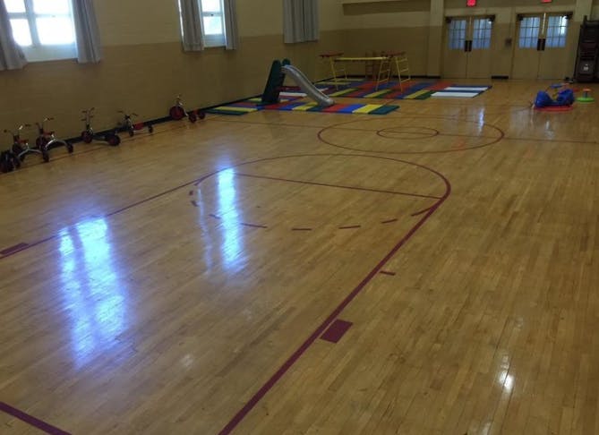 Empty gymnasium with basketball court lines and play equipment
