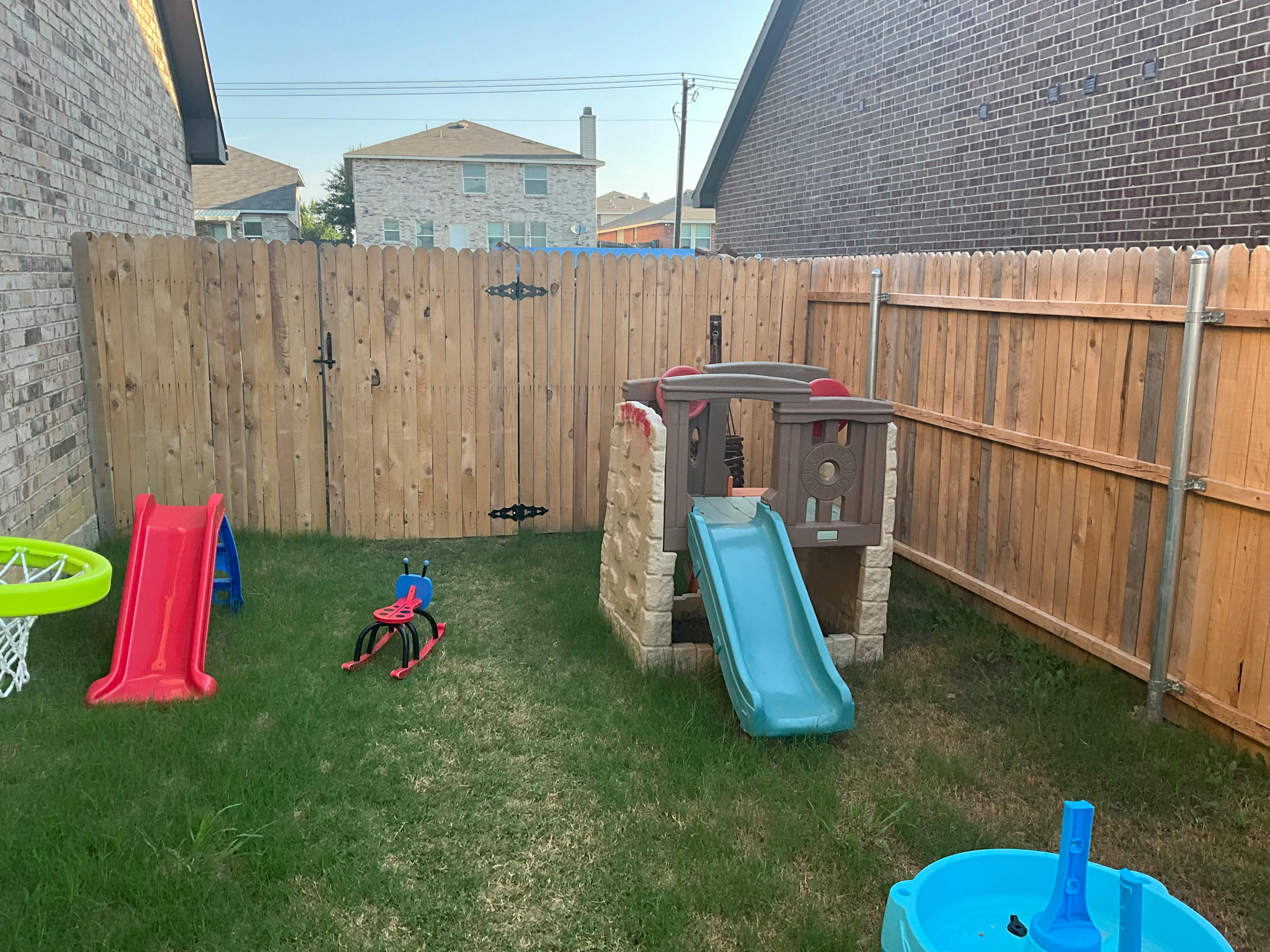 Backyard with play equipment including slides and a playhouse