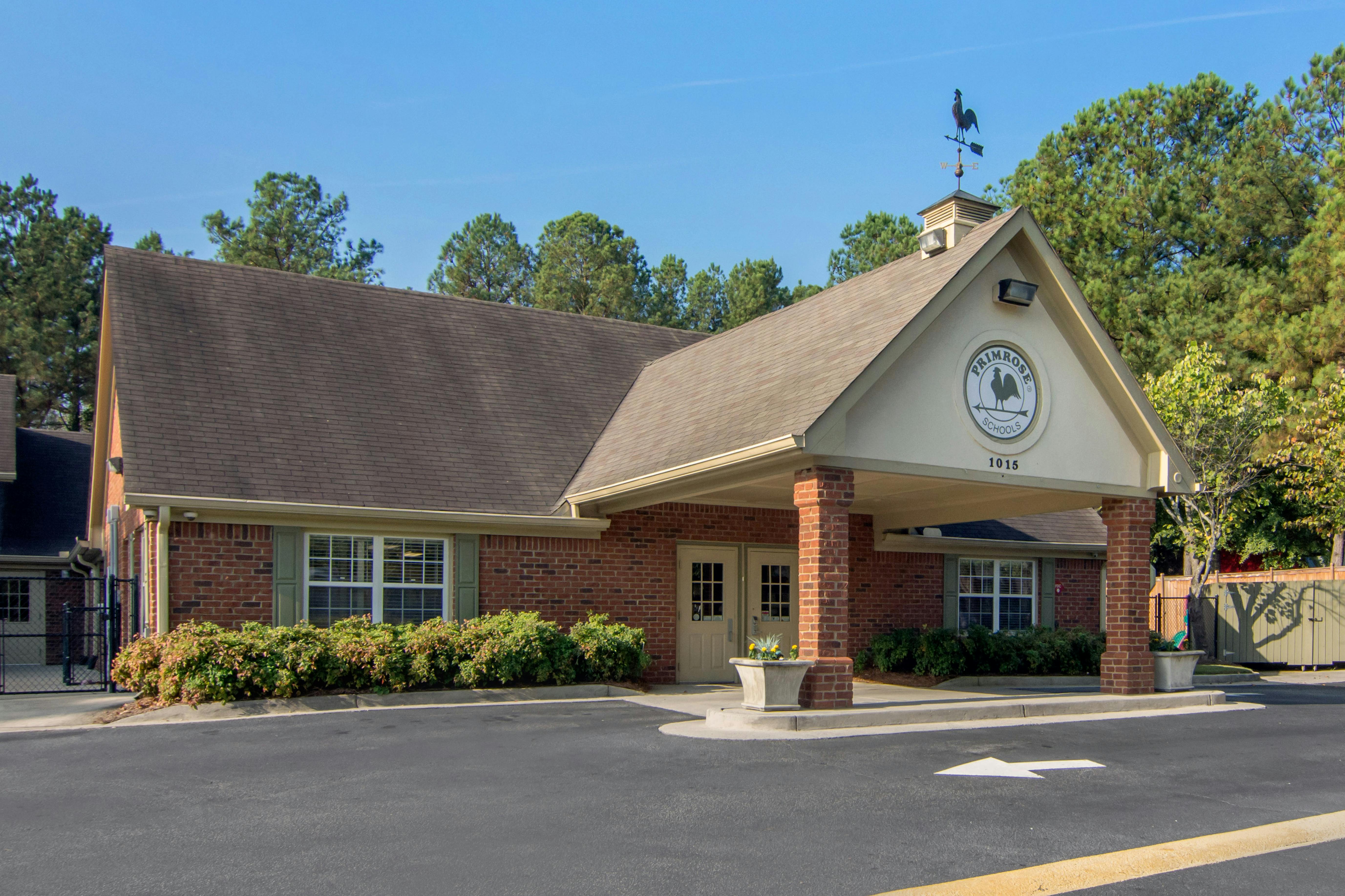 Brick building with a covered entrance and a sign that says Primrose Schools