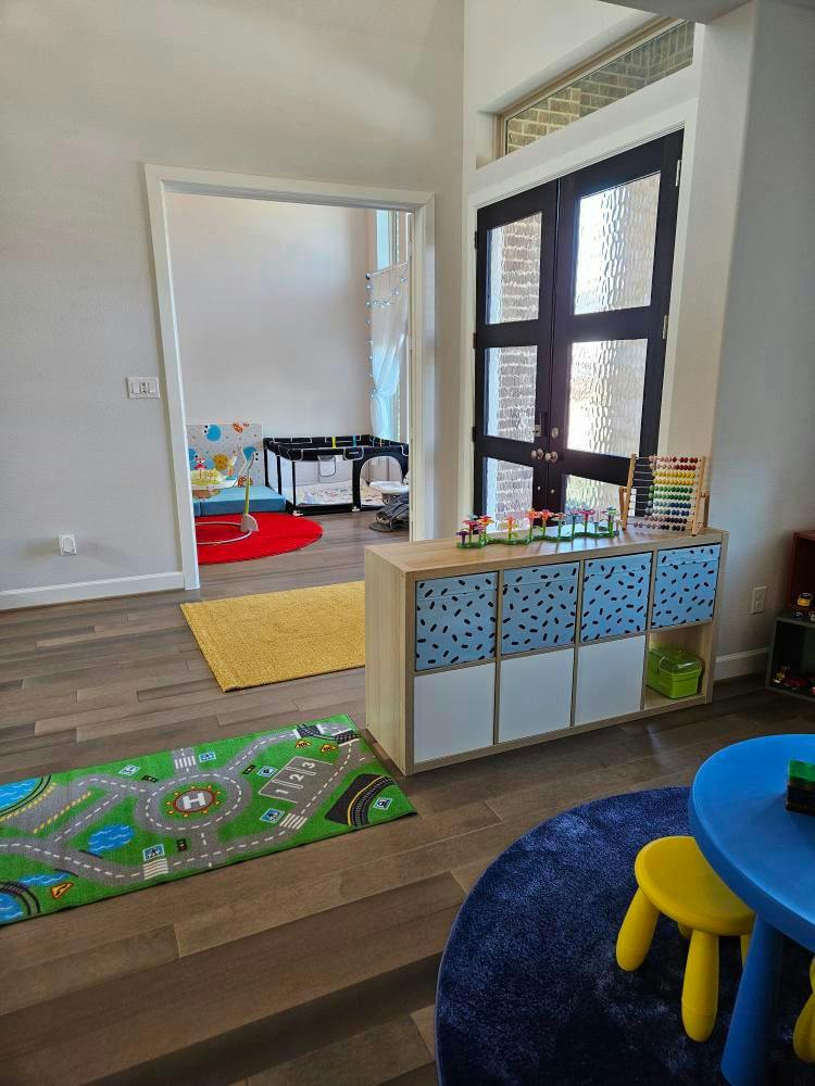 Playroom with toy storage, play mat, and small table
