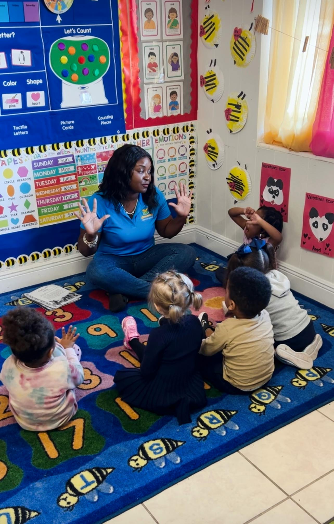 Person sitting on floor with children in a classroom
