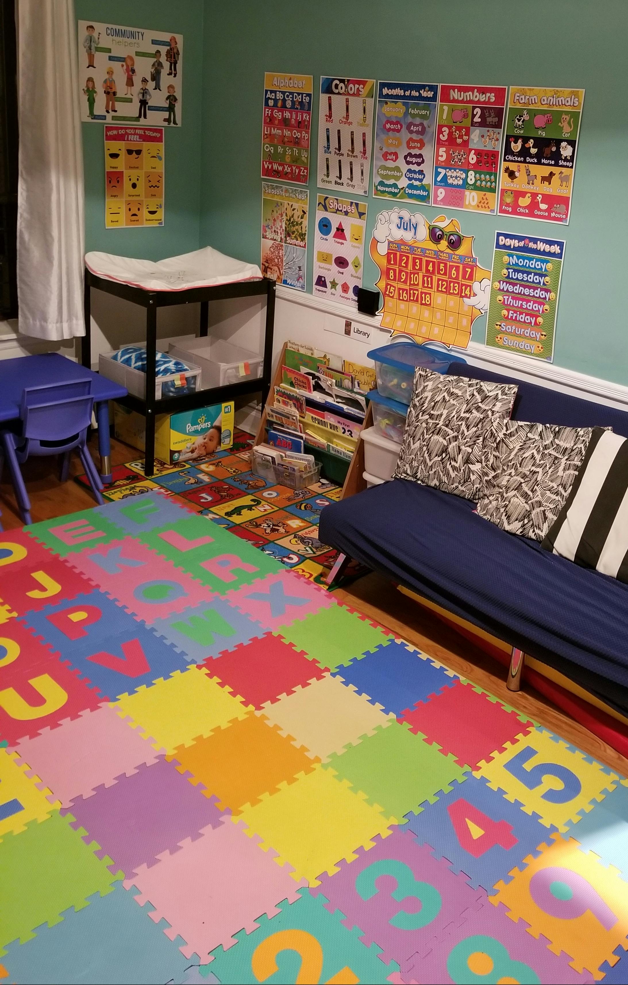 Playroom with colorful alphabet and number floor mats, posters on wall