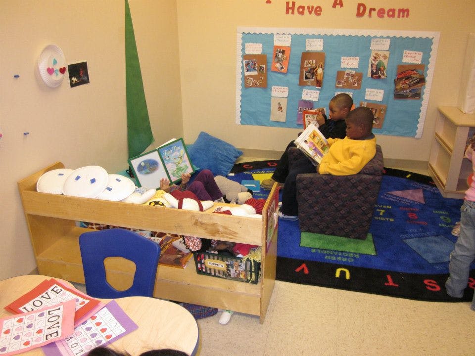 Two children reading a book together in a classroom
